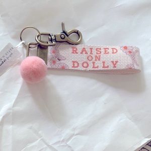 NWT. Raised On Dolly keychain. White/pink/brass